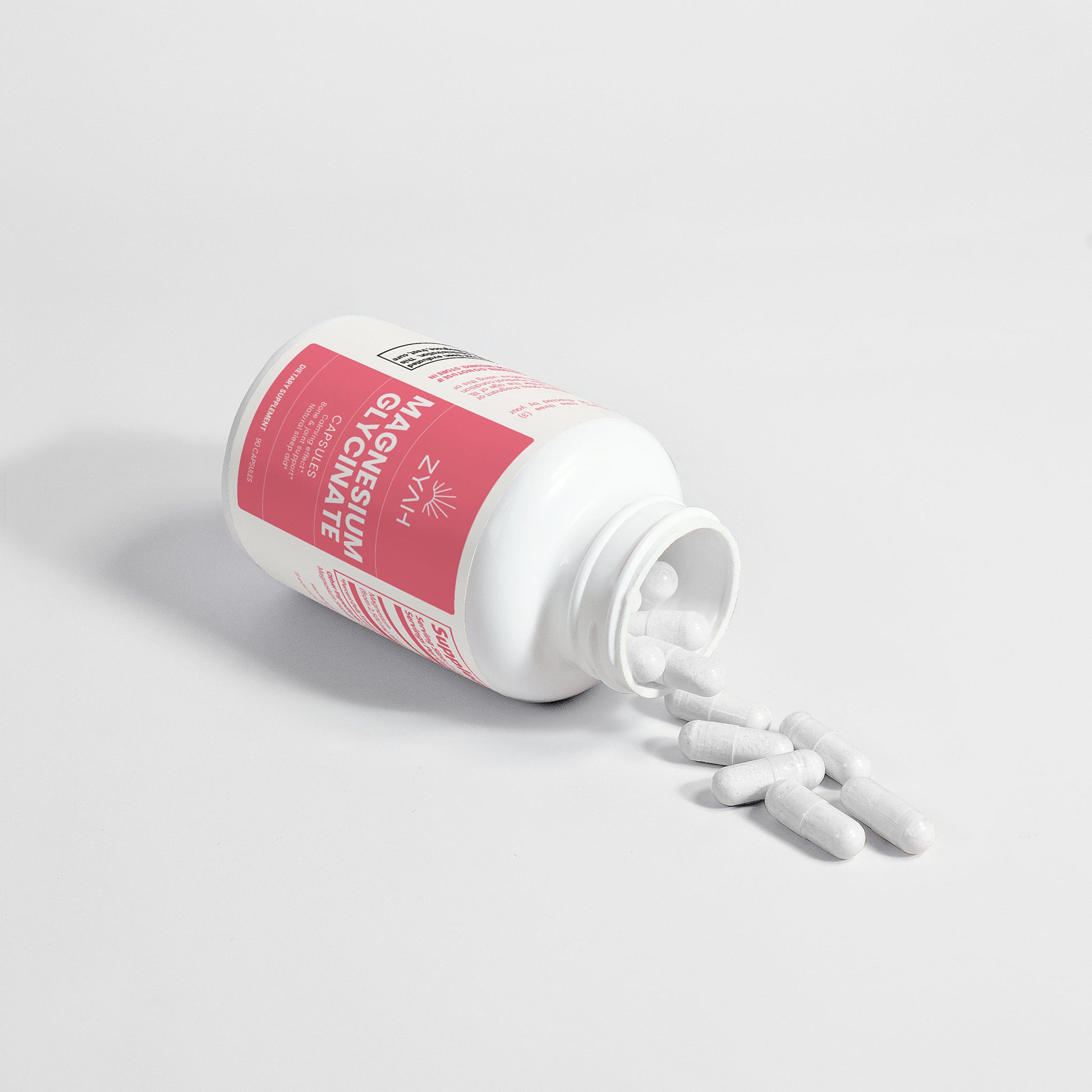 Supplement bottle with white capsules spilling out on a light gray background