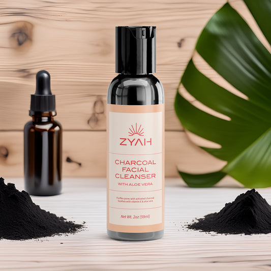 Zyah charcoal facial cleanser bottle with black powder and dropper bottle on a wooden surface.